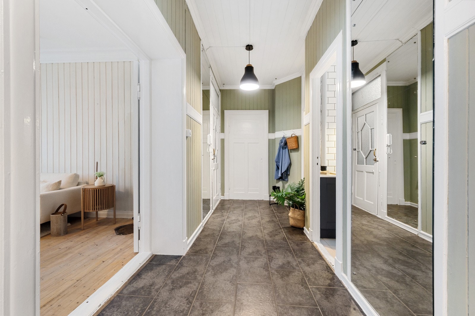 Den brunbeisede inngangsdøren med glassfelt leder inn til 94 kvm, hvor flere av byggets opprinnelige detaljer er bevart, blant annet listverk, veggpaneler, ildsteder og doble dører med utskjæringer. Galleribilde