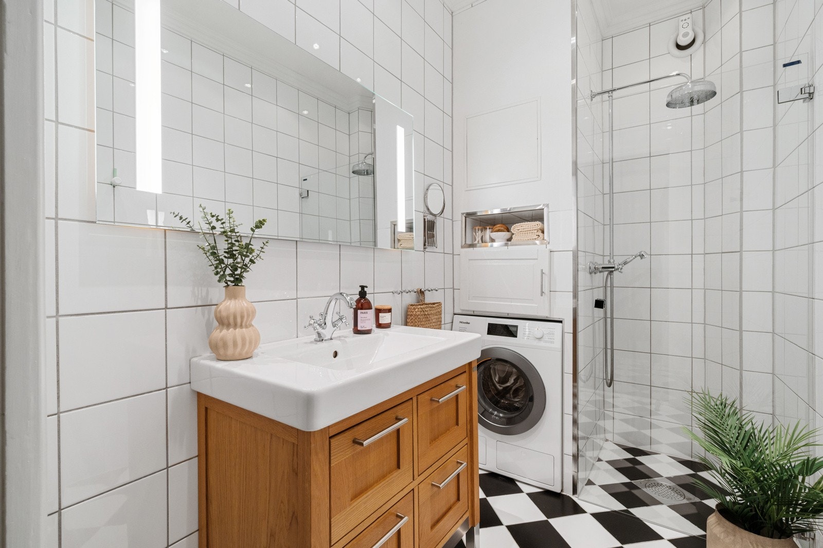 Badet er funksjonelt og gjennomtenkt innredet, med baderomsmøbel med profilerte fronter og heldekkende servant, samt speil med integrert belysning. Galleribilde