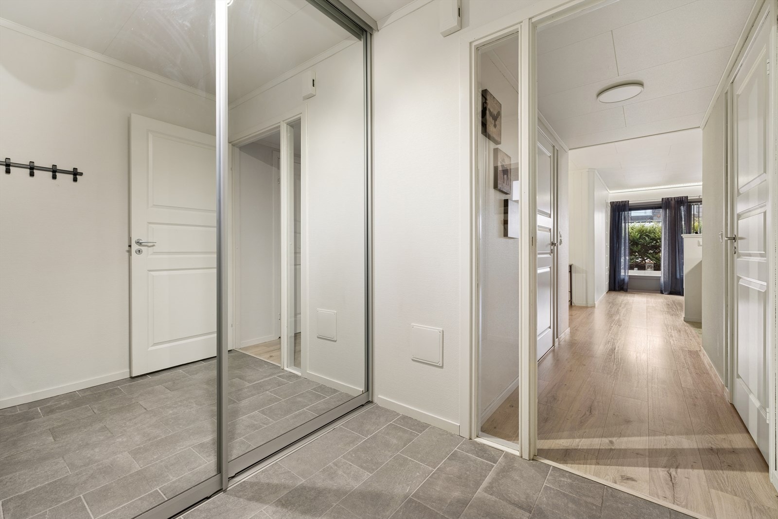Lys og innbydende entré med praktisk skyvedørsgarderobe og god oppbevaringsplass Galleribilde