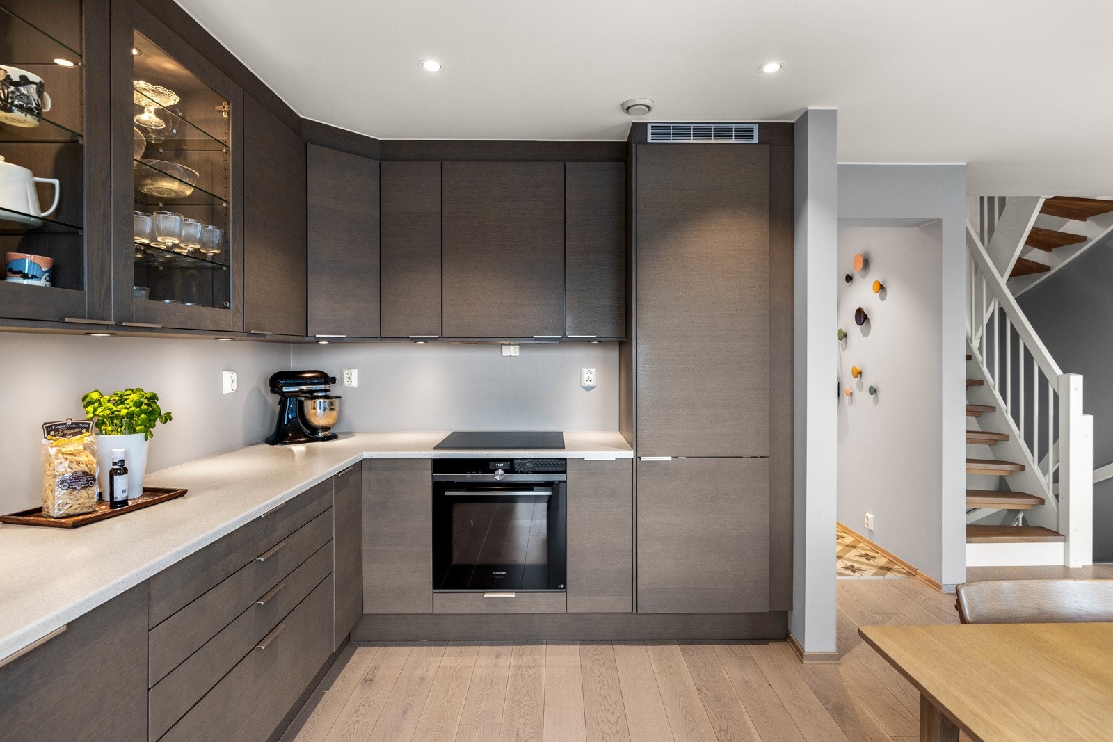 Påkostet kjøkken fra Sigdal. Moderne innredning med skifergrå fronter, laminat benkeplate med integrert kum og belysning under overskapene. Galleribilde