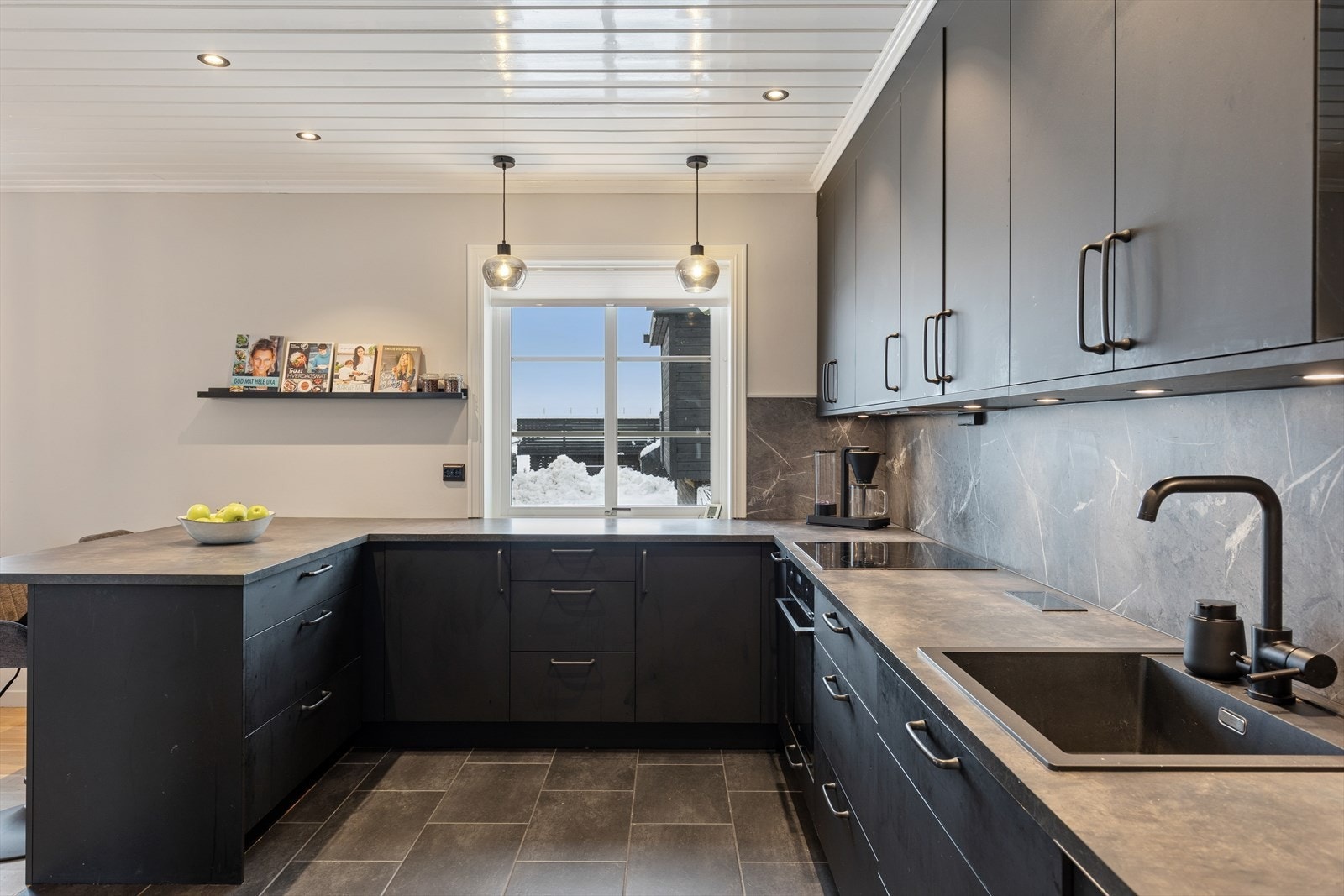 Her kan både hverdagskokken og gourmeten utfolde seg. Den åpne løsningen mot stuen gjør dette til et perfekt sted for familiens samlingspunkt, hvor matlaging og sosialt samvær går hånd i hånd. Kjøkkenventilator med avtrekk til det fri. Galleribilde