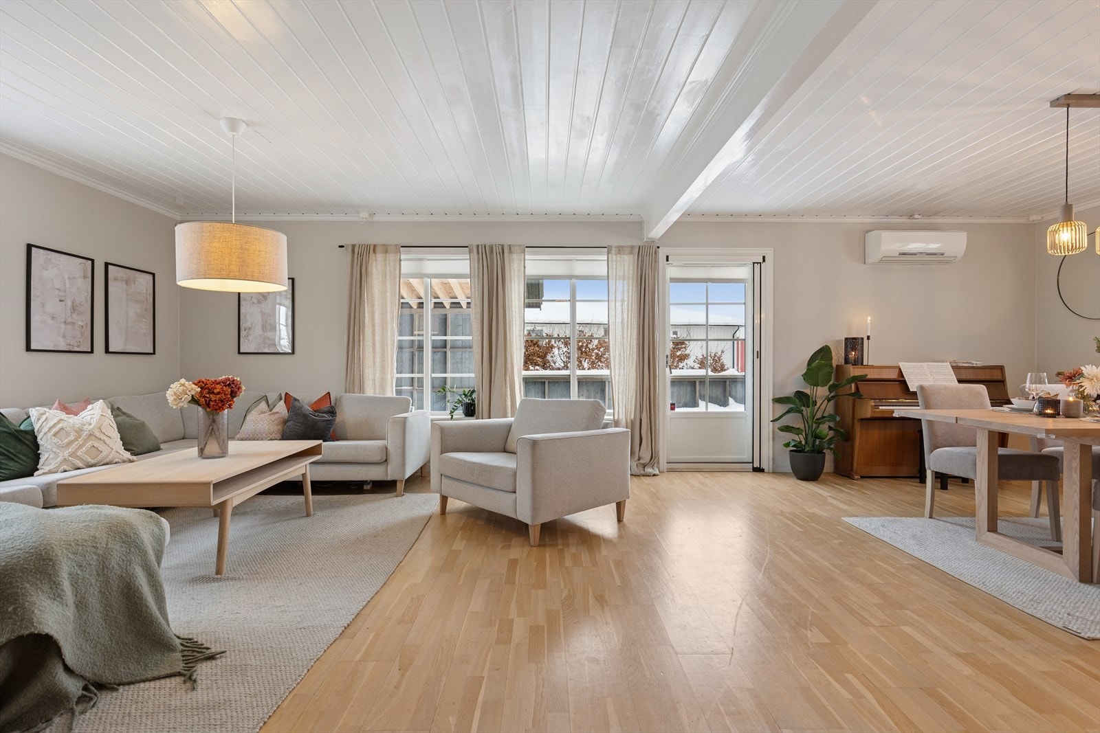 Den romslige stuen er hjemmets hjerte, fylt med naturlig lys fra store vindusflater som gir en lys og luftig atmosfære. Galleribilde