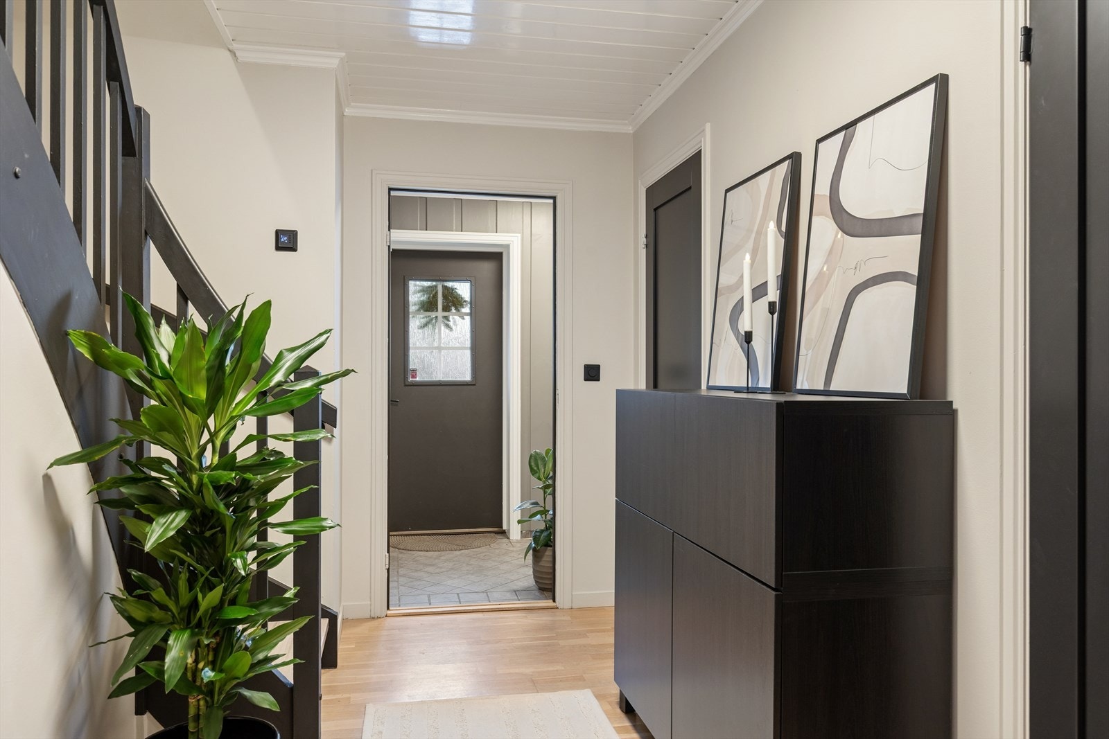 Inngangspartiet har rikellig plass for oppbevaring i egen skyvedørsgarderobe, knaggoppheng, kommoder etc. Plassen under trappen er også utnyttet og innredet til oppbevaringsrom. Praktisk vaskerom også ved inngangspartiet. Galleribilde