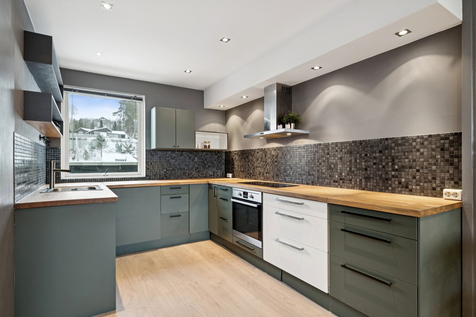 Kjøkkenet fremstår nytt og moderne med malte fronter og integrerte hvitevarer. Galleribilde