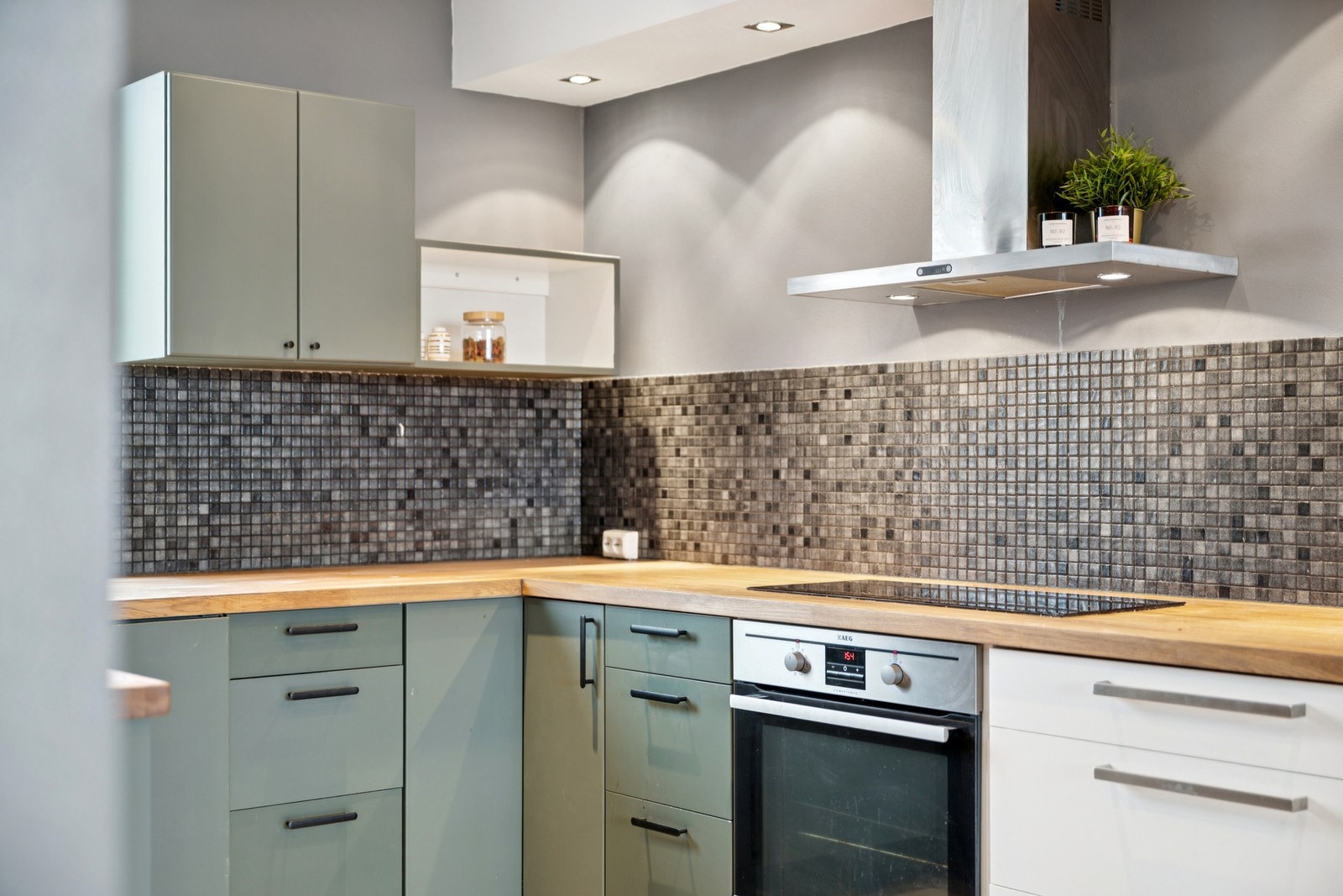 Utstyrt med integrerte kjøleskuffer, induksjonstopp, stekeovn og fryser, og gir en funksjonell og stilren kjøkkenløsning. Galleribilde