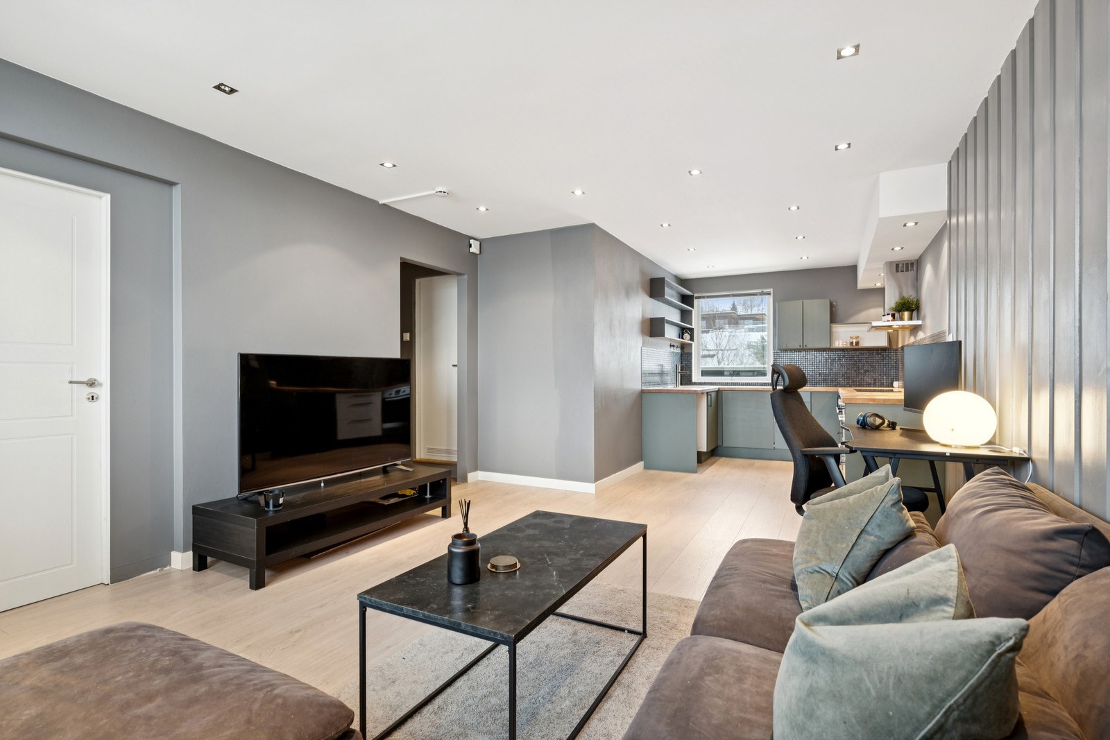 Stuen ligger i åpen løsning mot kjøkkenet og fremstår som lys og luftig. Galleribilde