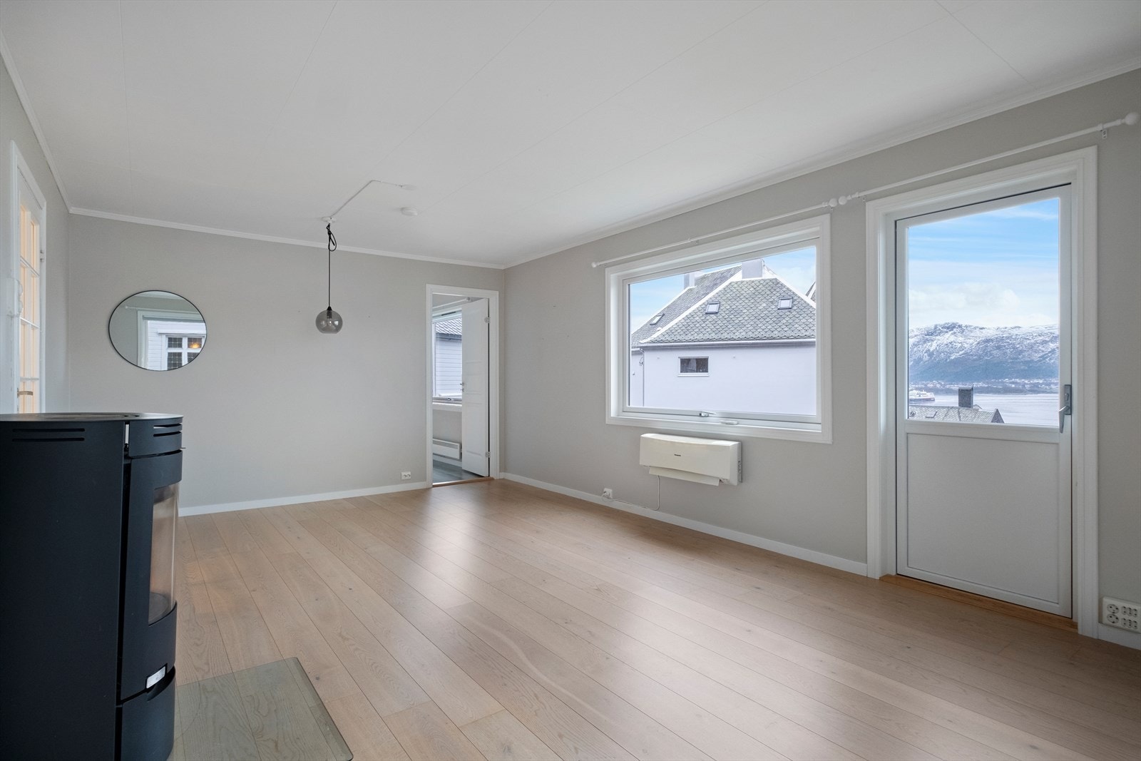 Stor og romslig stue med vedovn og utgang til balkong. Galleribilde