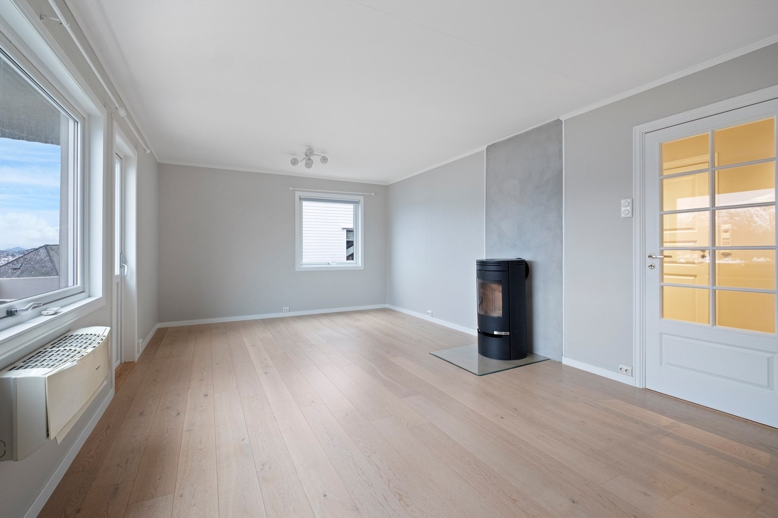 Stor og romslig stue med vedovn og utgang til balkong. Galleribilde