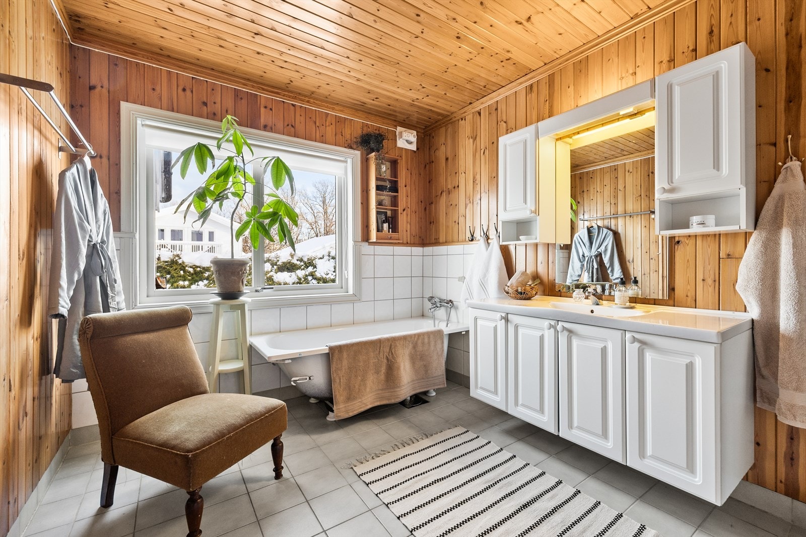 Badet er av eldre dato med panel på vegger og fliser på gulv, og har en sjarmerende stil som står godt til boligen. Galleribilde