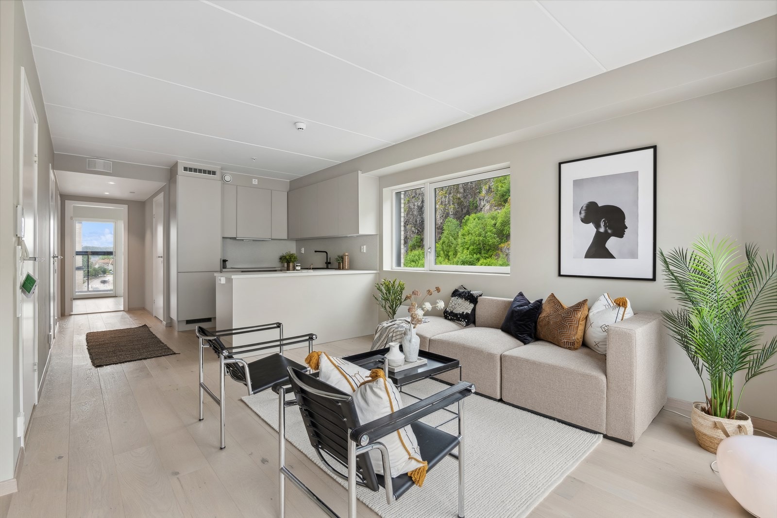 Stuen er åpen og lys med åpen kjøkkenløsning Galleribilde