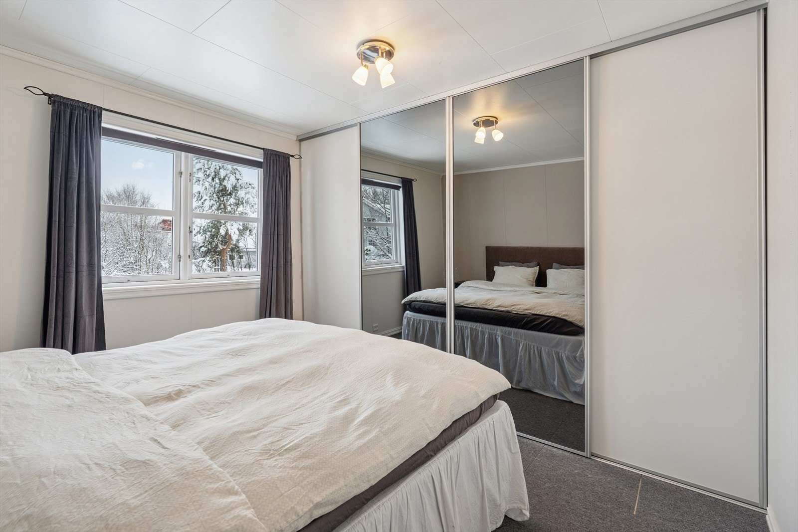 Stort og praktisk skyvedørs garderobe på soverommet. Galleribilde