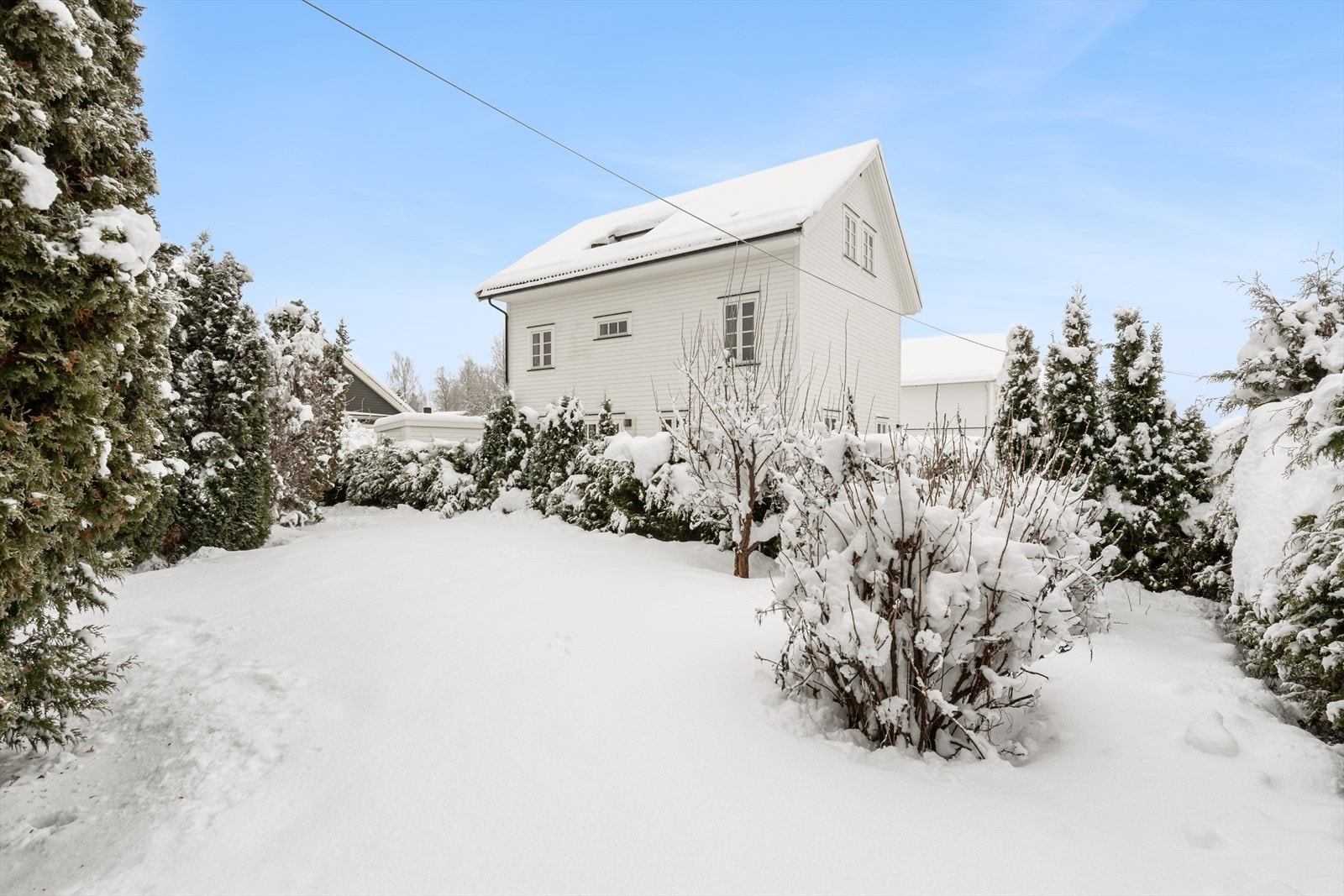 Overblikk over tomten mot sør - opparbeidet med plenarealer og diverse beplantning. Galleribilde