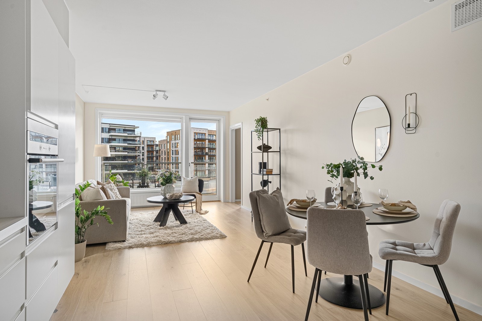 Stue og kjøkken i åpen løsning med god plass til både sofagruppe og spisebord Galleribilde