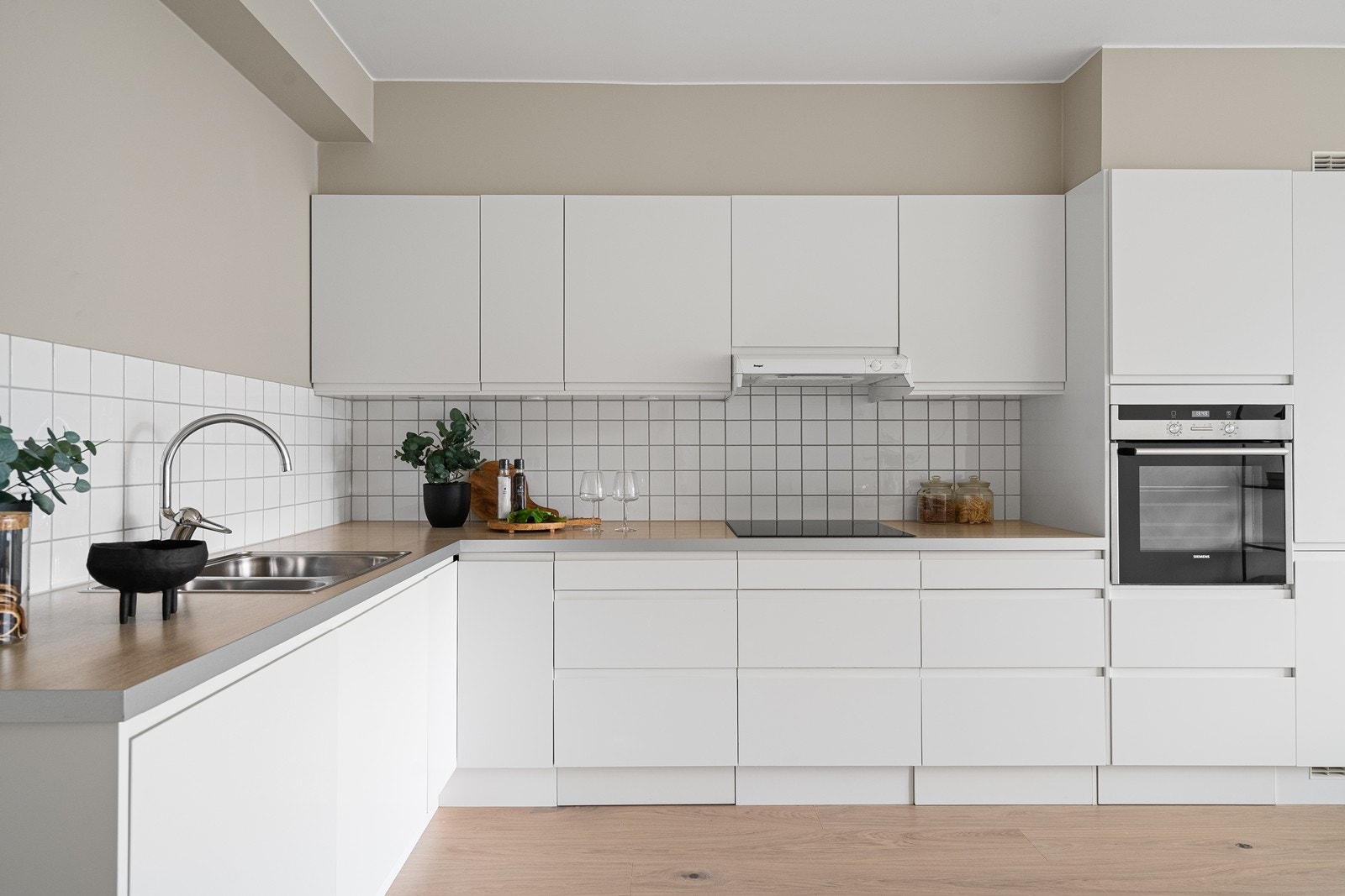 Pent lyst kjøkken med god skap- og benkplass til oppbevaring og matlaging Galleribilde