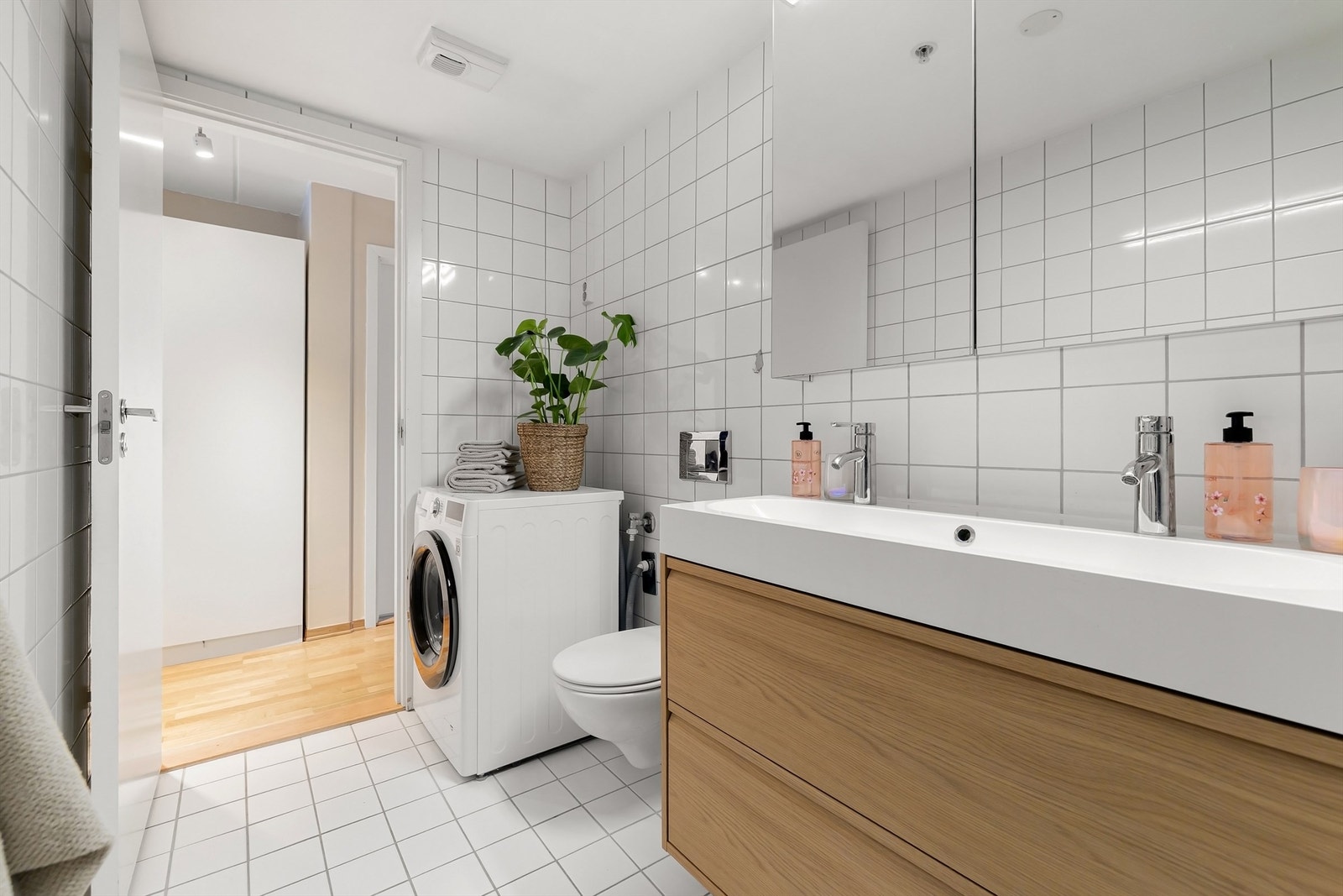 Videre er badet utstyrt med heldekkende, dobbel servant med skuffeinnredning og speilskap med belysning over Galleribilde