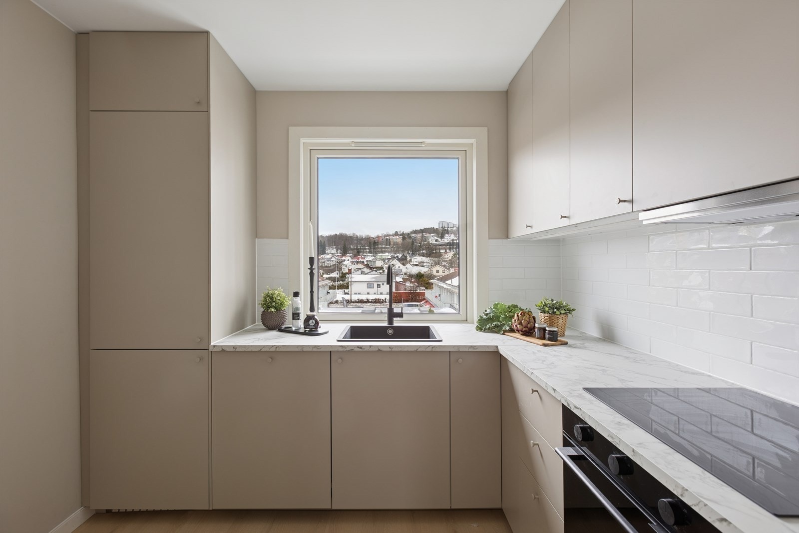 Tidløs kjøkkeninnredning med beige fronter, benkeplater i laminat, og integrerte hvitevarer Galleribilde