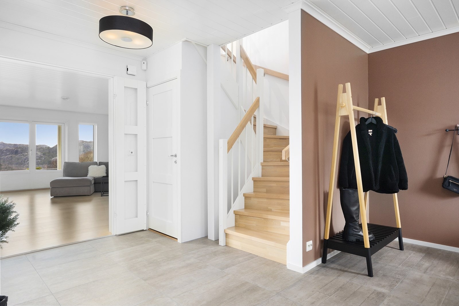 Boligens entré ønsker deg velkommen med en stilren og luftig atmosfære. Med fliser på gulvet og varmekabler får du både et moderne utseende og praktisk komfort. Galleribilde