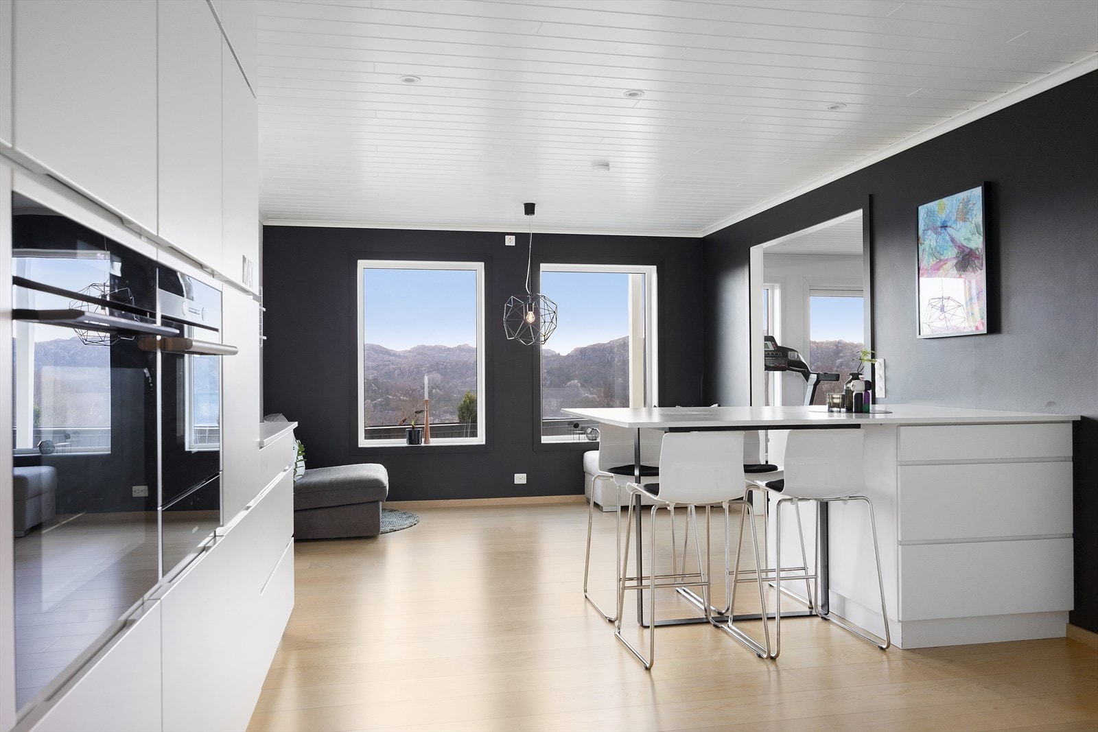 Det lyse og moderne kjøkkenet har slette fronter og integrerte hvitevarer som gir et stilrent og helhetlig preg. Her er det god skap- og arbeidsplass, samt en praktisk kjøkkenøy som både har oppbevaringsplass og fungerer som et koselig spiseområde. Galleribilde