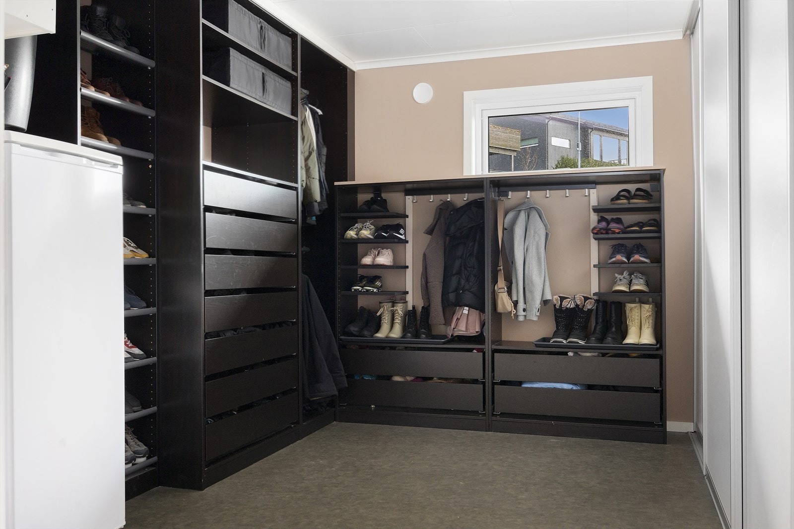 Praktisk bi-inngang til vaskerommet med tilknyttet bod, en smart løsning som gir rikelig oppbevaringsplass til yttertøy og sko. Galleribilde