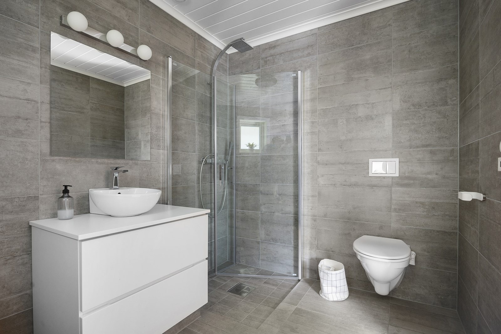 Bad i hovedetasjen som fremstår moderne med høy standard. Badet er utstyrt med vegghengt toalett, dusj og stilren baderomsinnredning. Galleribilde