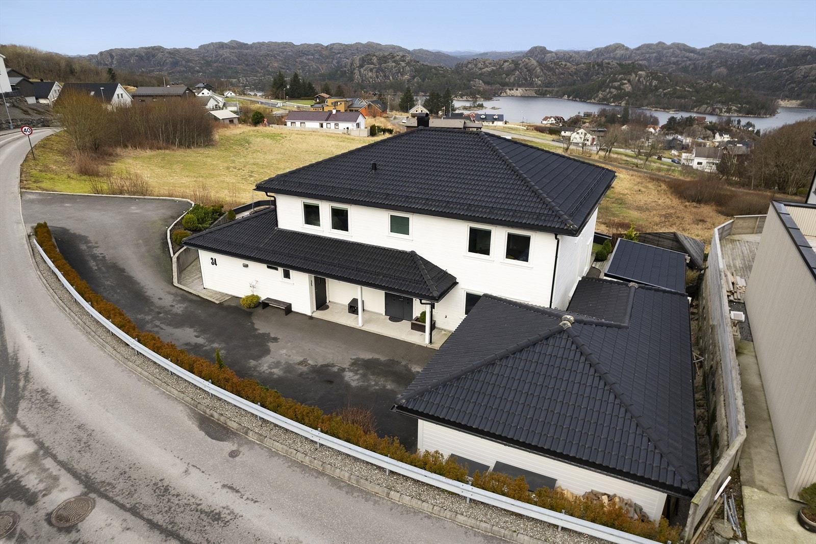 Uteområdet tilhørende denne eiendommen er like praktisk og pent som boligen selv. Tomten er lettstelt og samtidig funksjonell, med asfaltert gårdsrom som gir god plass til parkering. Galleribilde