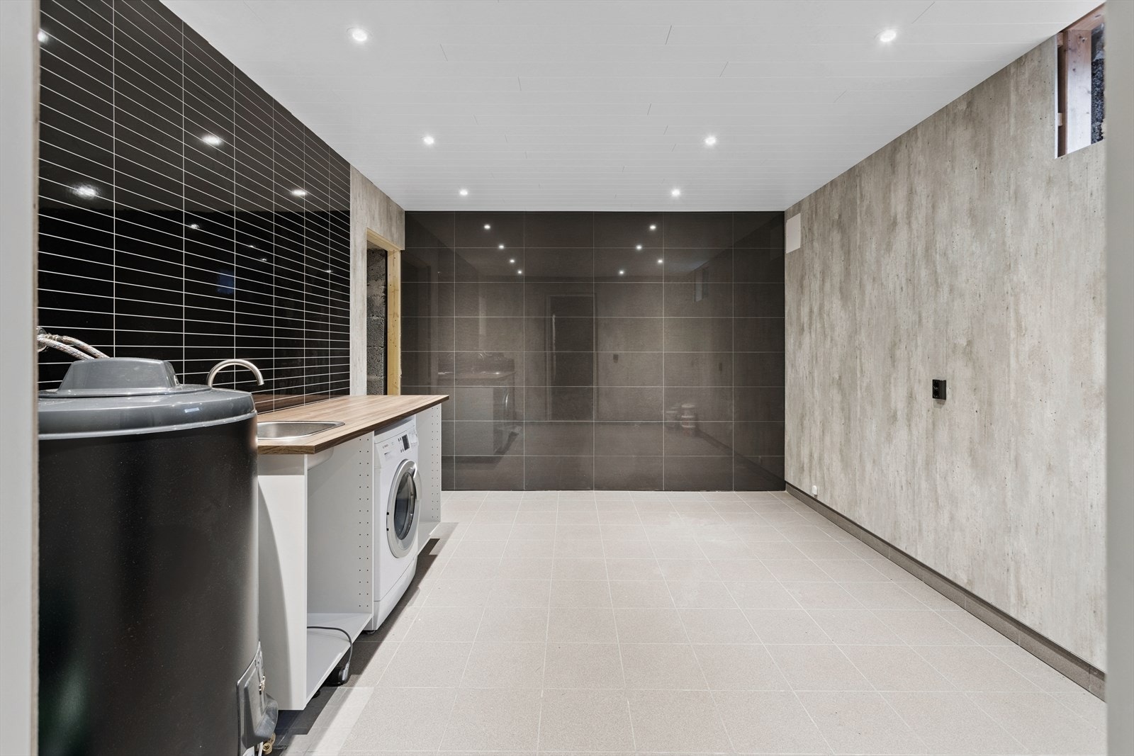 Romslig vaskerom med flislagt gulv og god plass til tekniske installasjoner. Rommet er ikke ferdigstilt. Galleribilde