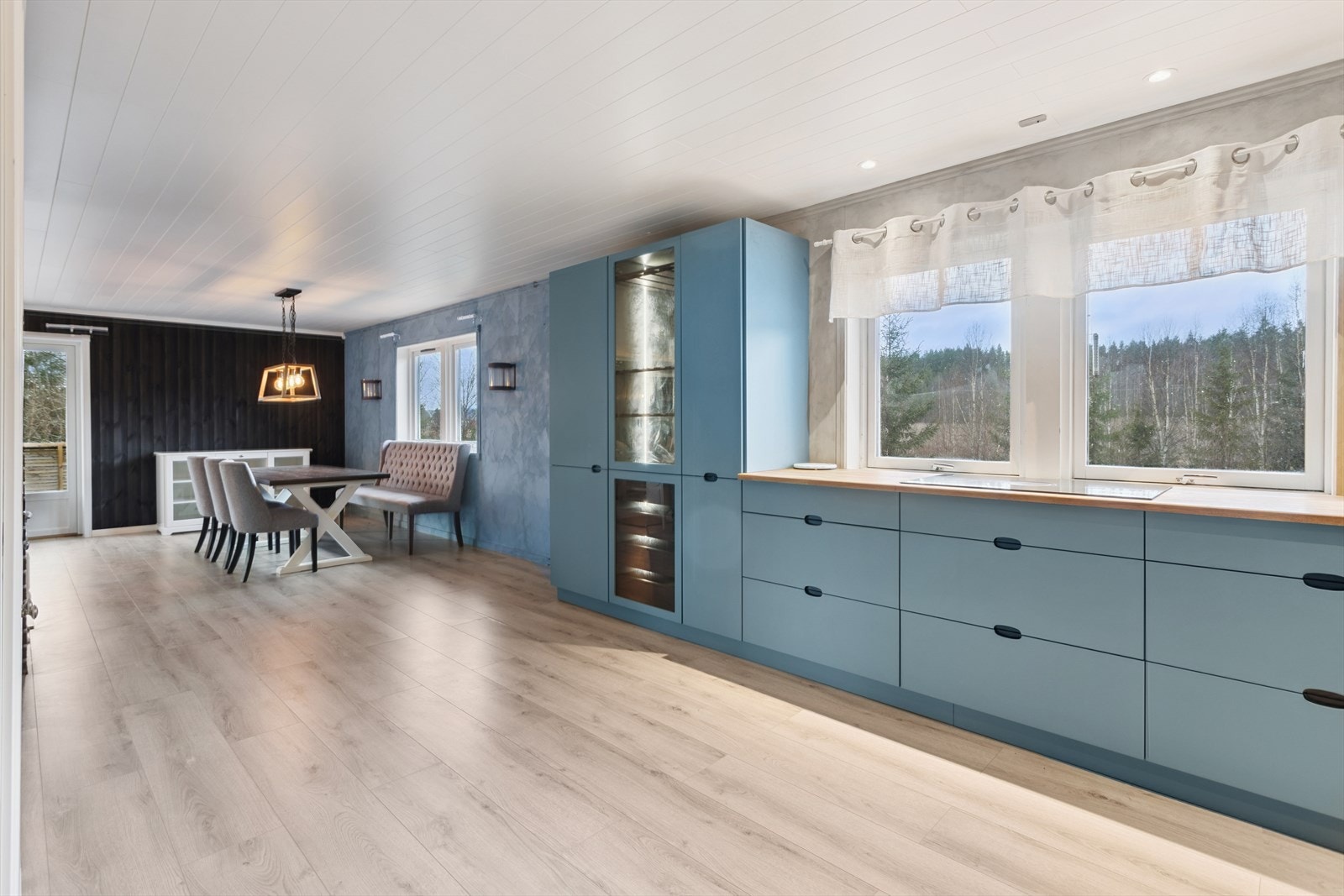 Kjøkkeninnredningen er utformet med en praktisk L-løsning og vitrineskap. Galleribilde