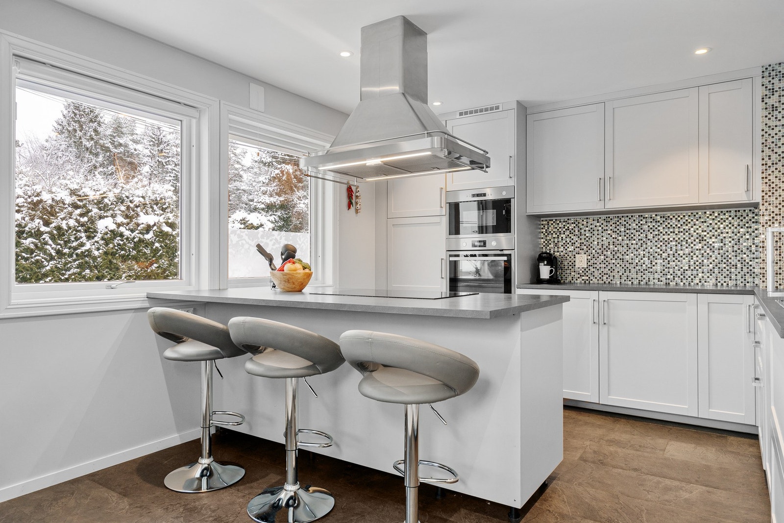 Kjøkkenet har flotte barstoler og store vinduer som slipper inn rikelig med lys. Galleribilde