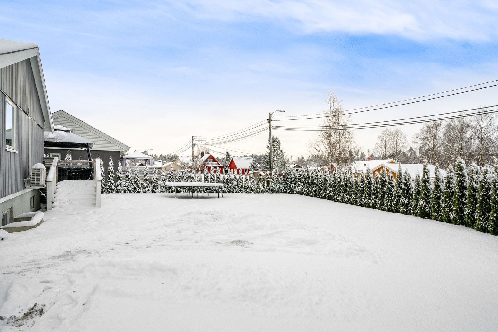 Det er trapp ned til meget romslig, solrik og barnevennlig hage fra terrassen. Galleribilde