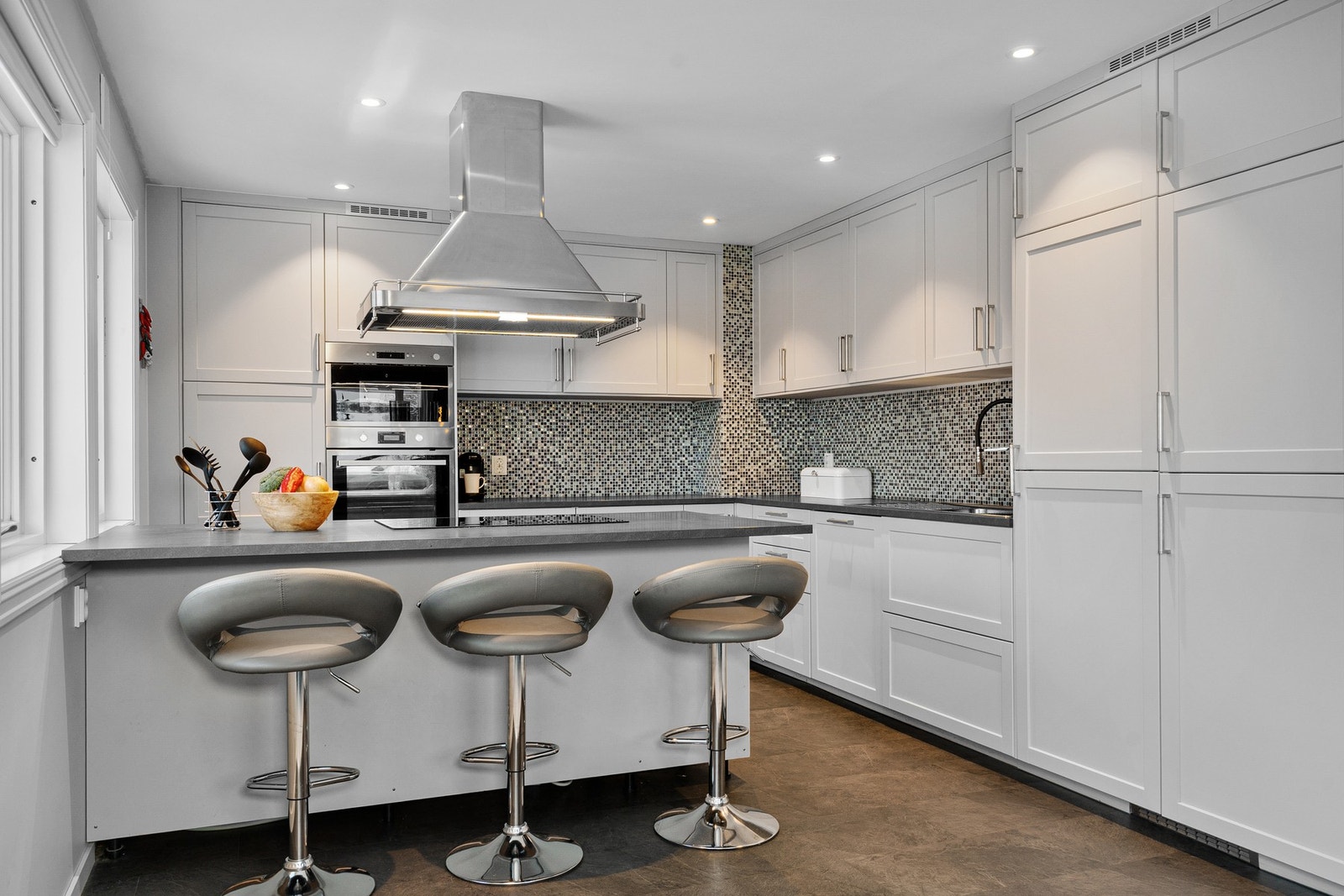 Det er montert stilrene fliser over kjøkkenbenken og downlights i himling. Galleribilde