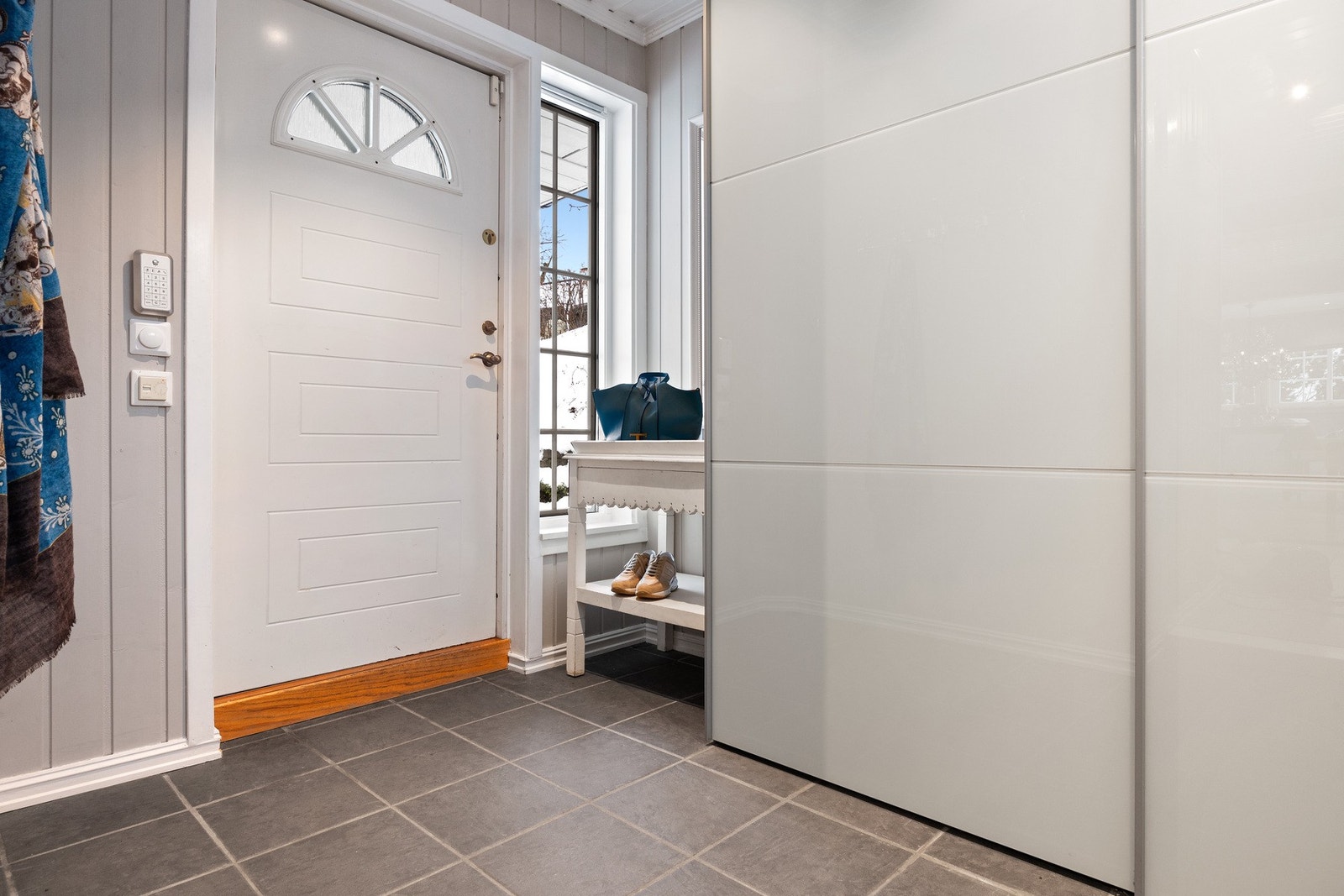 Flislagt entré med skyvedørsgarderobe. Galleribilde