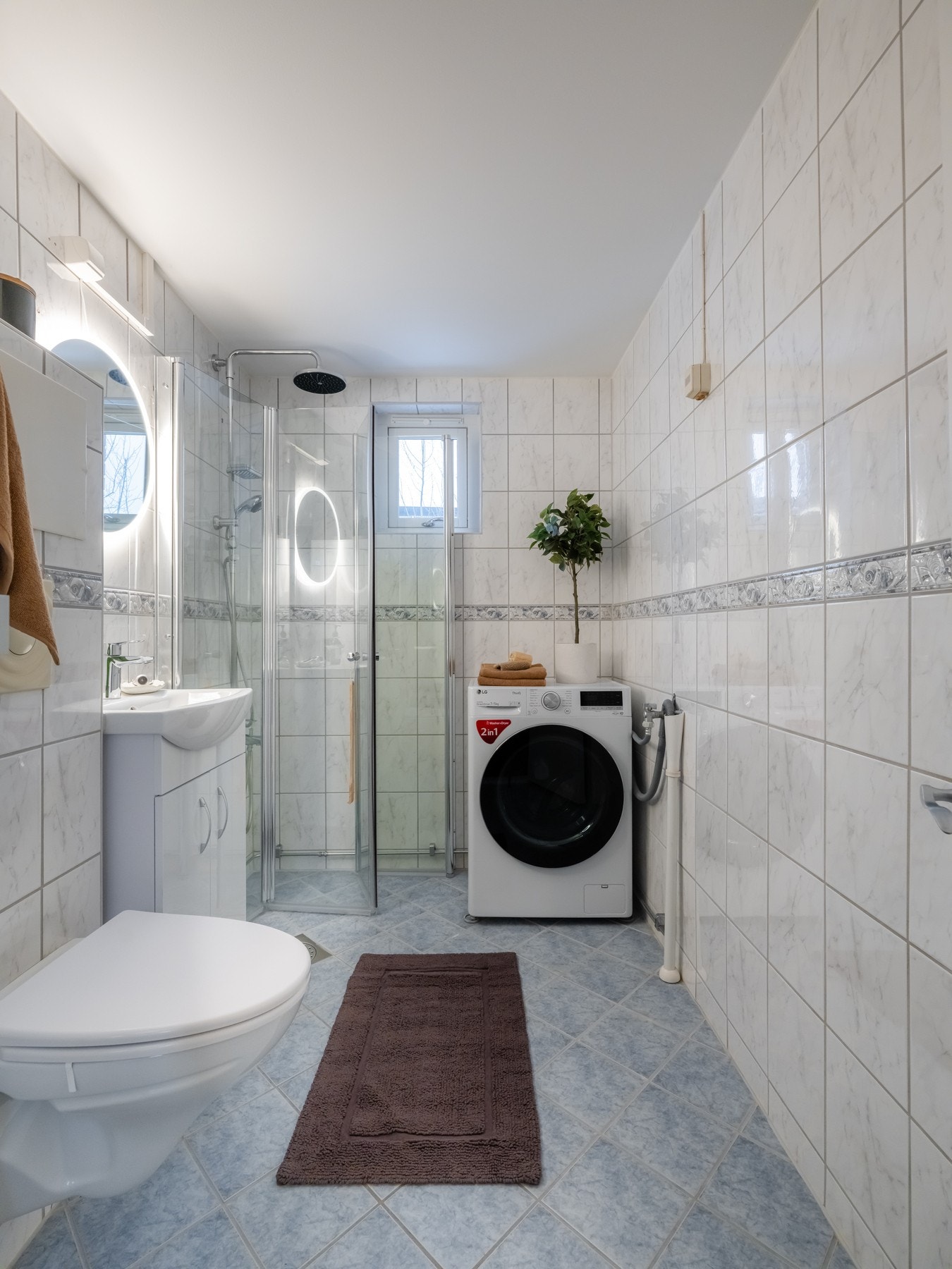 Badet er utstyrt med skap med glatte fronter, servant, vegghengt toalett og regnfalldusj med innfellbare dusjdører. På badet er det opplegg for vaskemaskin. Galleribilde