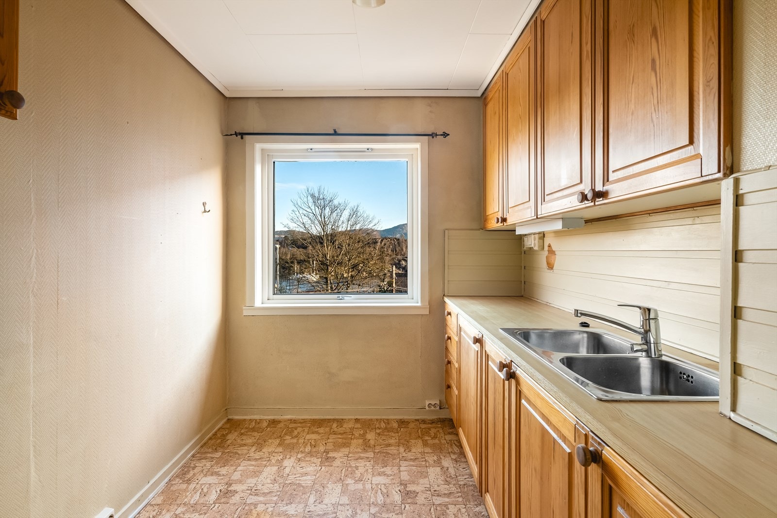 Leilighetens kjøkken har innredning med profilerte fronter, laminert benkeplate og utslagsvask i stål. Galleribilde