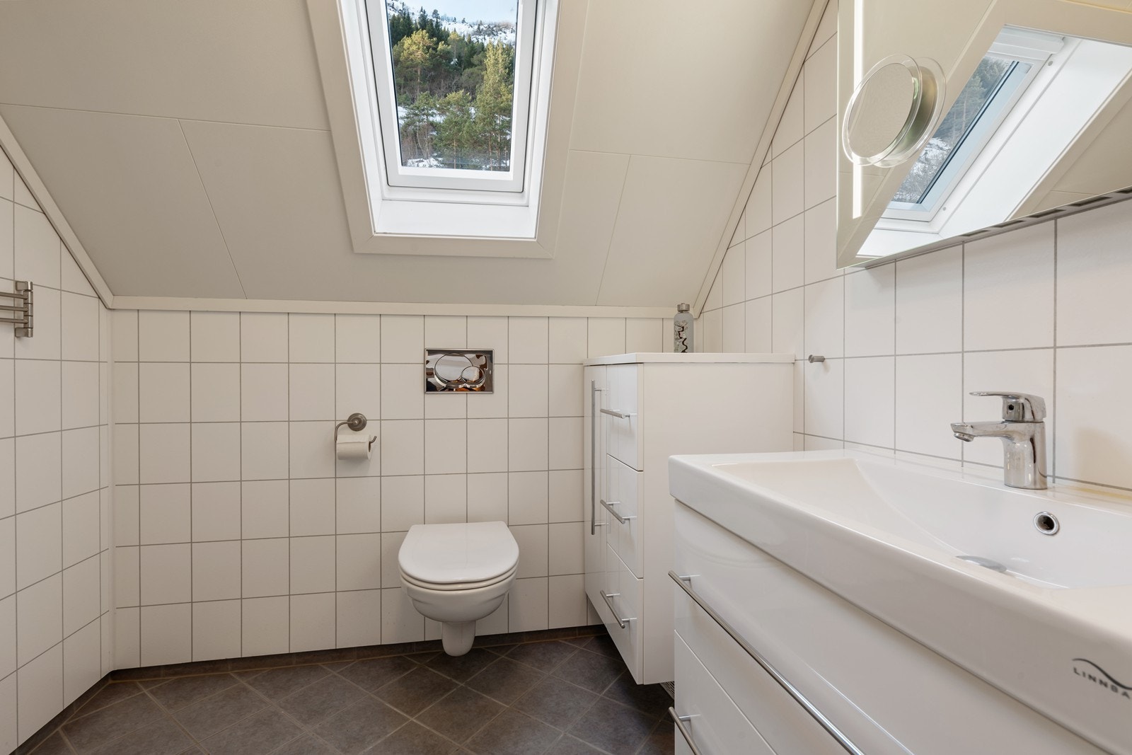 Lyst og pent baderom med flislagt gulv med varmekabler i. Galleribilde