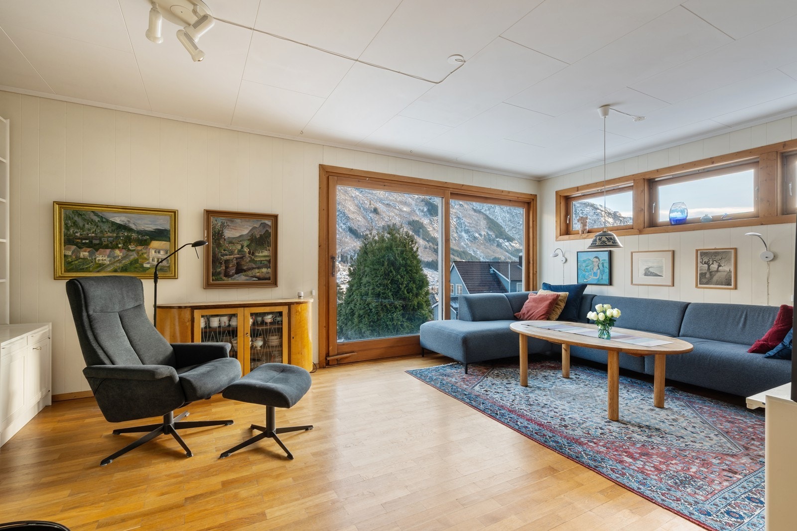 Lys og luftig stue med store vindusflater som byr på rikelig med dagslys og vakker utsikt mot fjord og fjell. Galleribilde