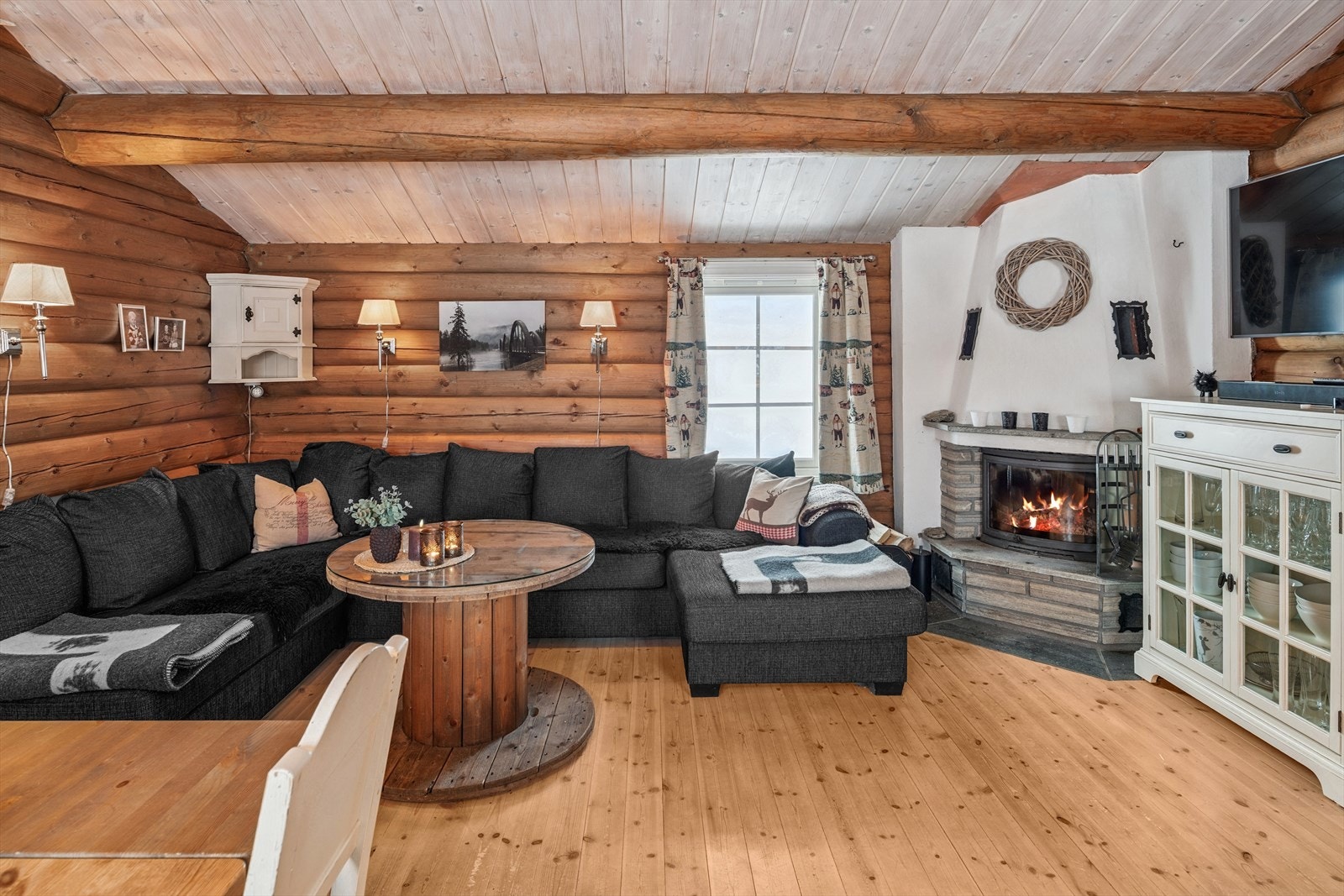 Stuen har god plass til en romslig sofagruppe, med varme fra peis med lukket innsats samt en panelovn på veggen. Galleribilde