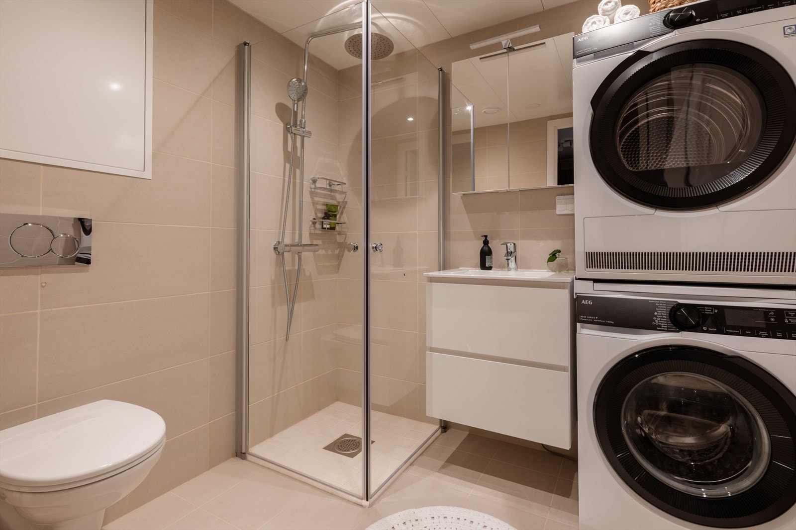 Badet er utstyrt med vegghengt toalett, dusjhjørne og opplegg for vaskesøyle. Galleribilde