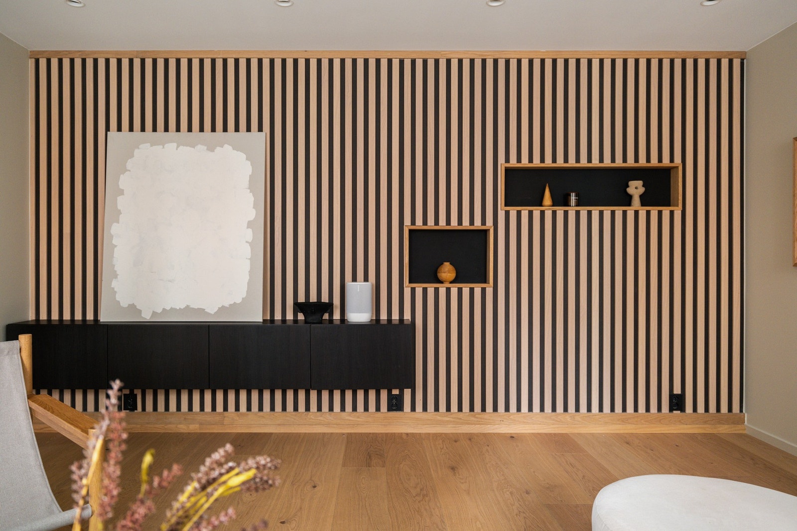 Stilren stue med parkett og spesialtilpasset spilevegg. Galleribilde