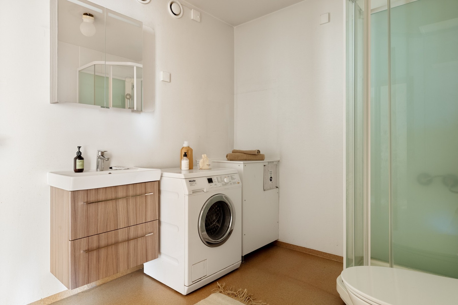 Badet er innredet med toalett, baderomsinnredning, dusjkabinett og opplegg for vaskemaskin. Galleribilde