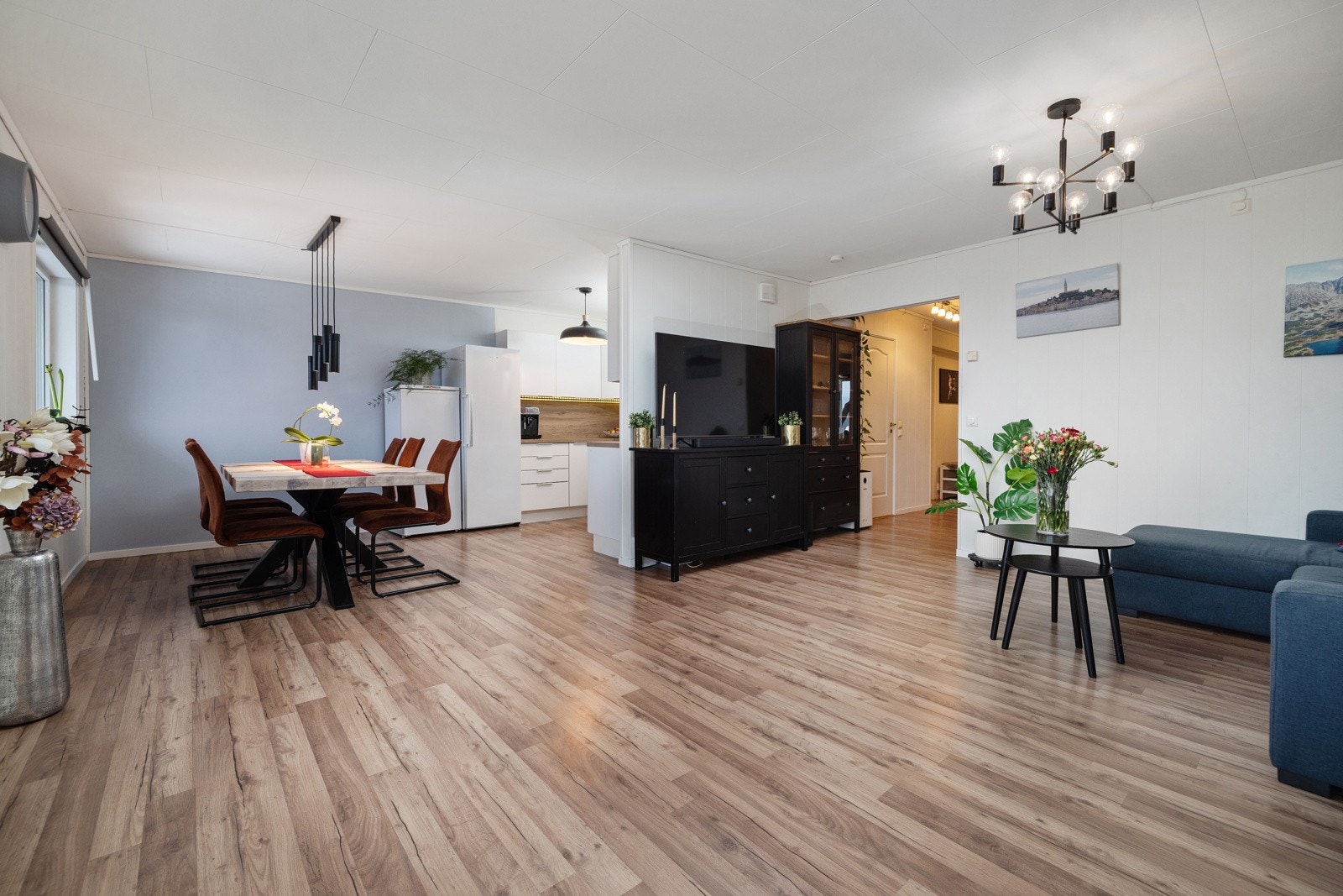 Leiligheten har et romslig oppholdsrom med stue og kjøkken i åpen løsning, likevel i egne soner. Galleribilde