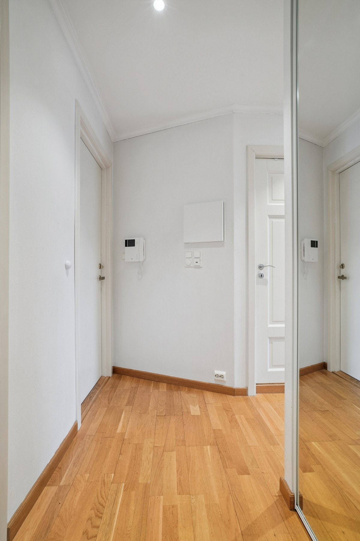 Entré med parkettgulv og malte flater på veggene. Galleribilde