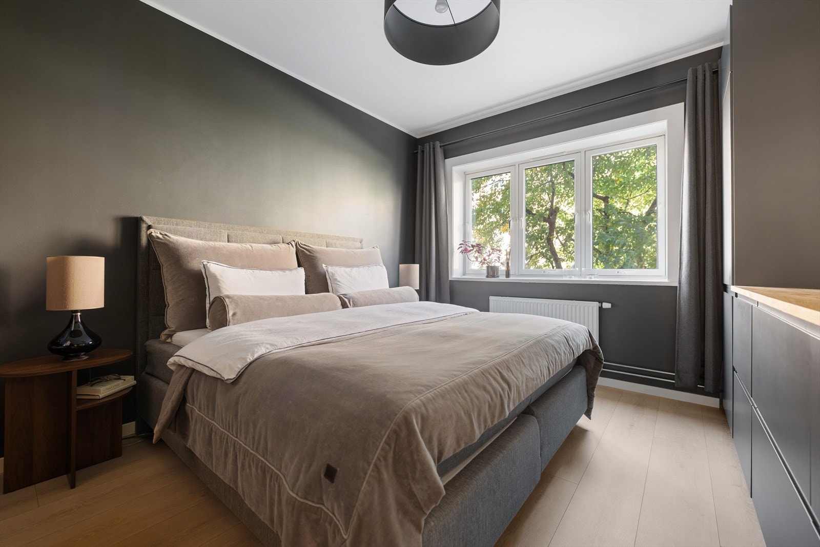 Romslig hovedsoverom med plass til dobbeltseng, nattbord og oppbevaring Galleribilde