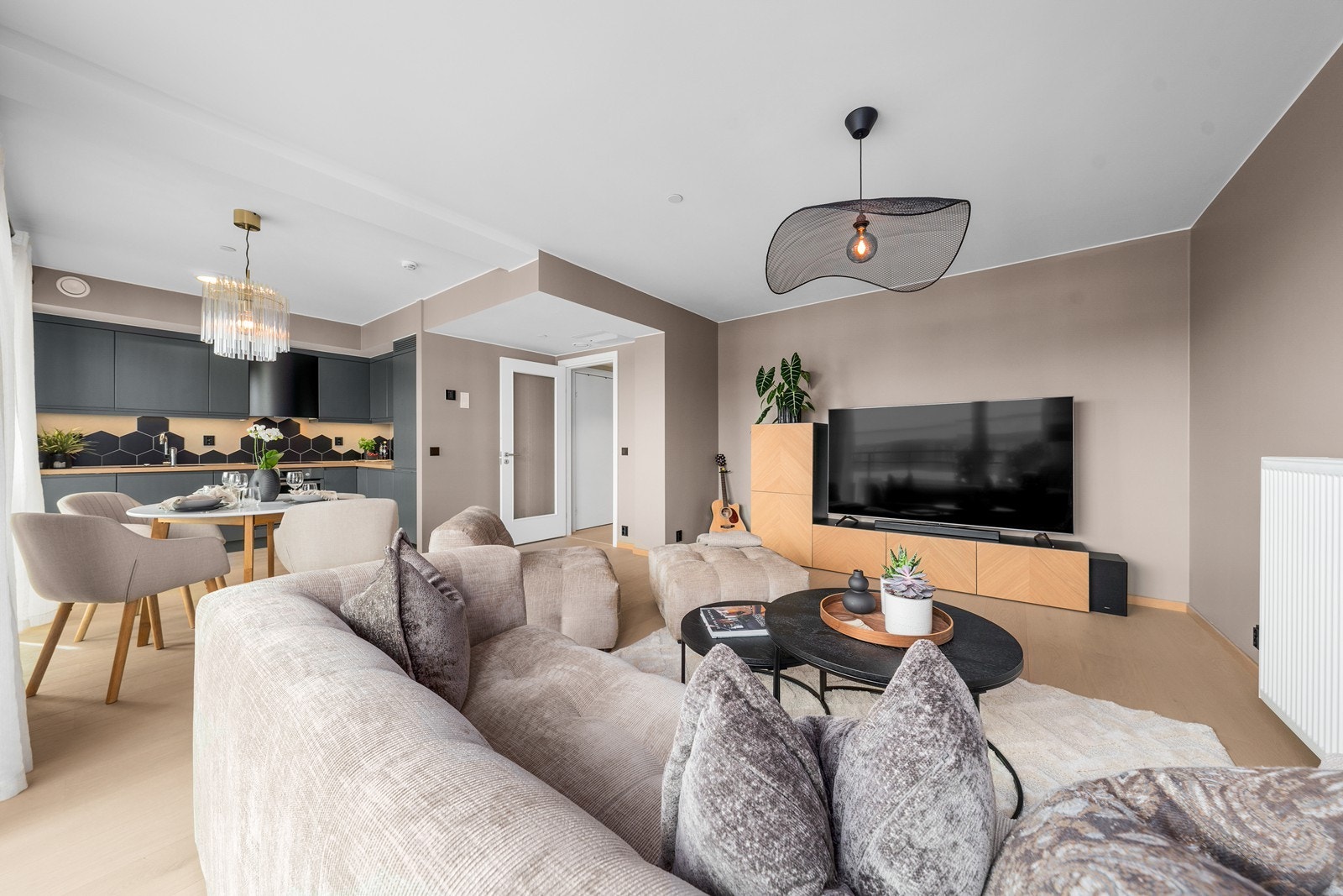 Den åpne planløsningen mellom kjøkken og stue skaper en sosial sone med plass til både spisebord og sofakrok - perfekt for både hverdag og selskap. Galleribilde