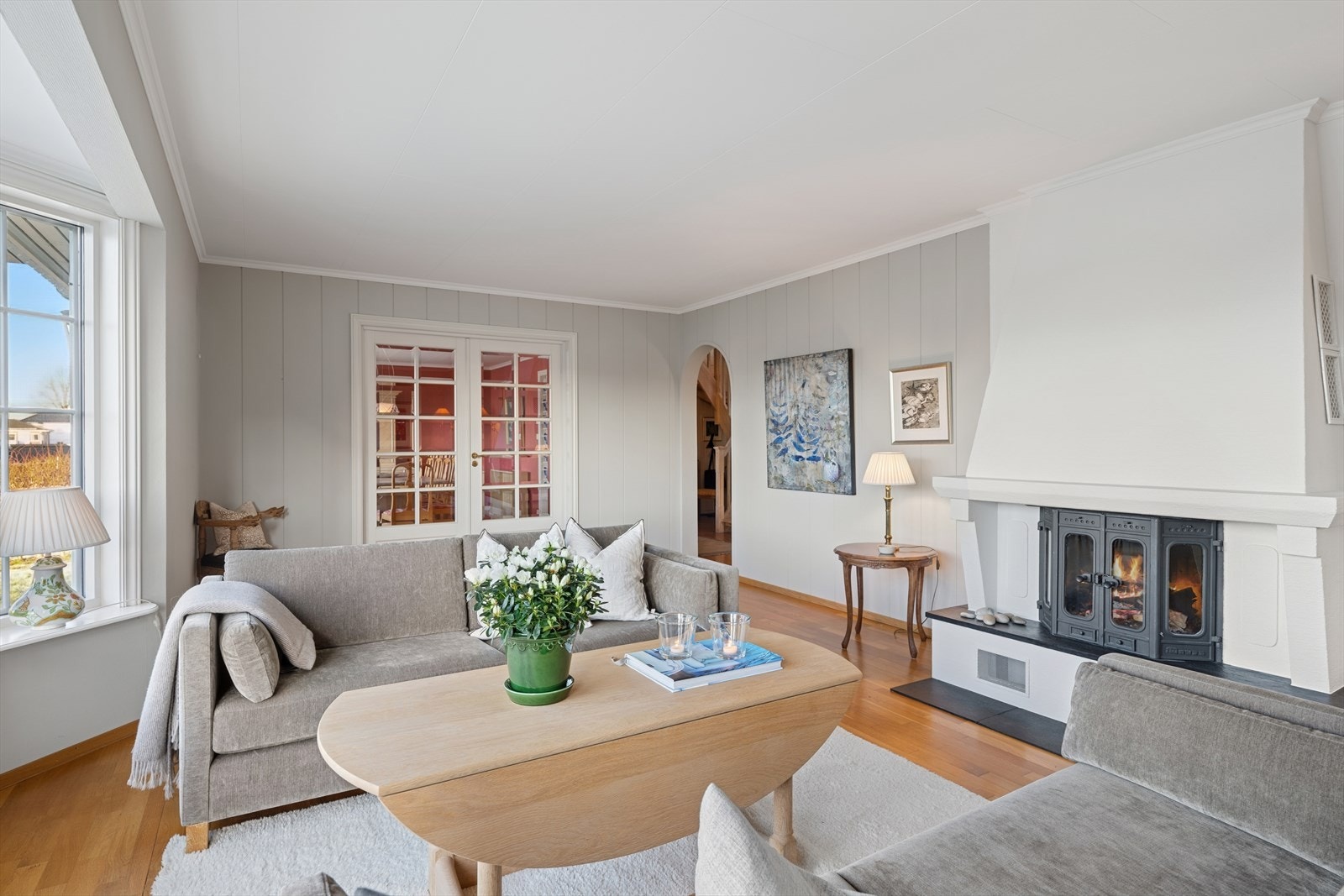 Store vindusflater og glassdører inn til spisestuen gir et klassisk og flott preg til stuen. Galleribilde