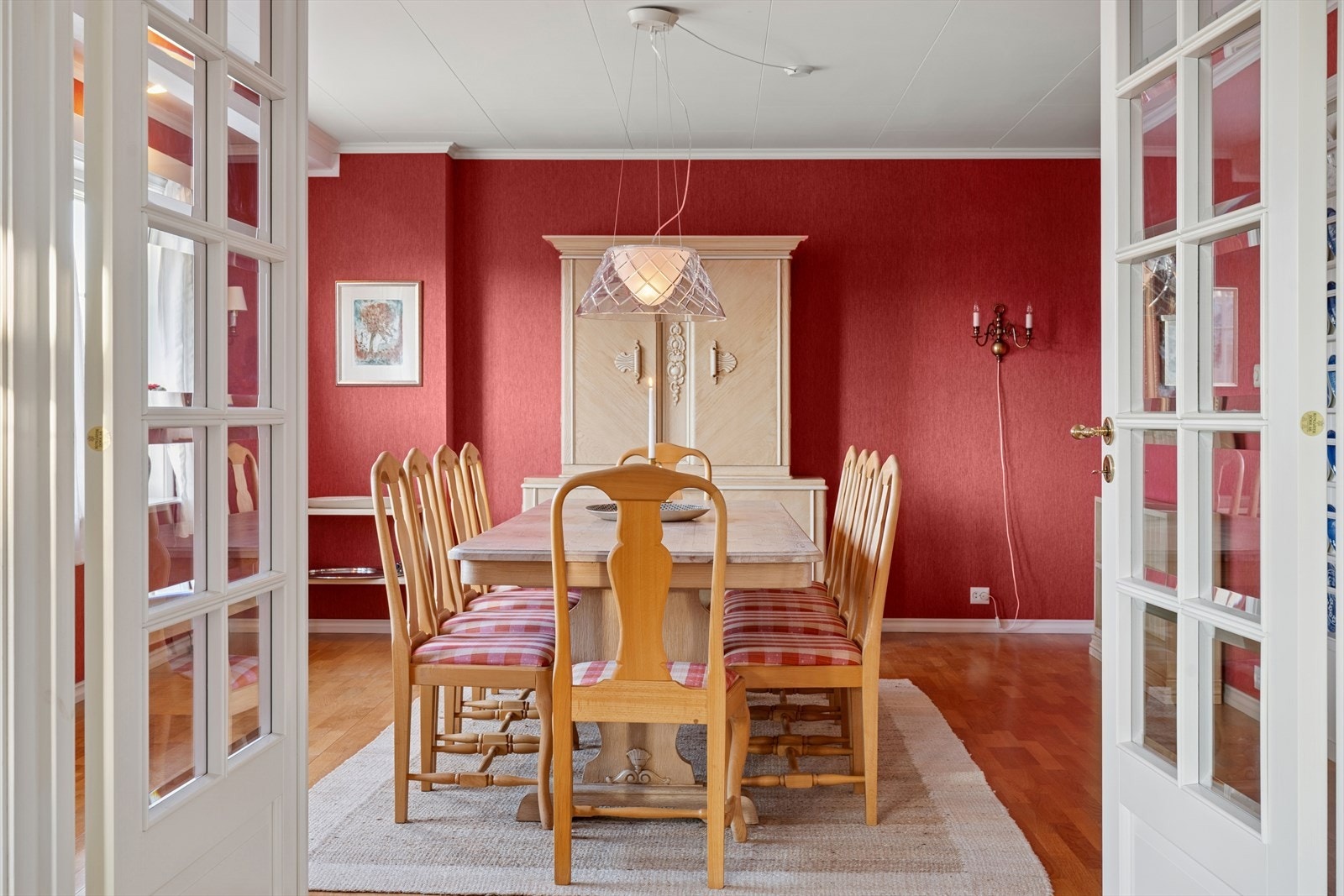 Franske dører gir tilgang til spisestuen med tapetkledde vegger. Galleribilde