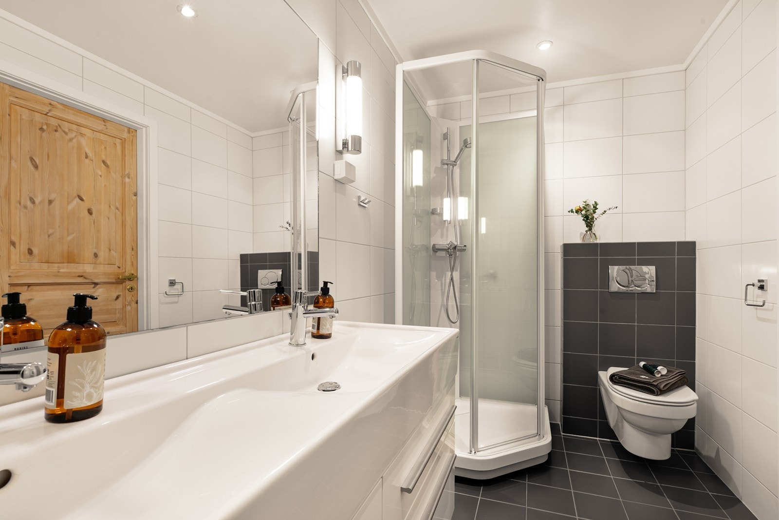 Badet har veggmontert toalett og et dusjkabinett med skyvedører. Galleribilde