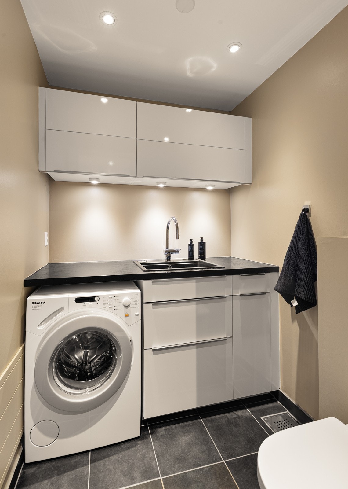 Praktisk vaskerom i første etasje med vegghengt toalett og opplegg for vaskemaskin. Galleribilde