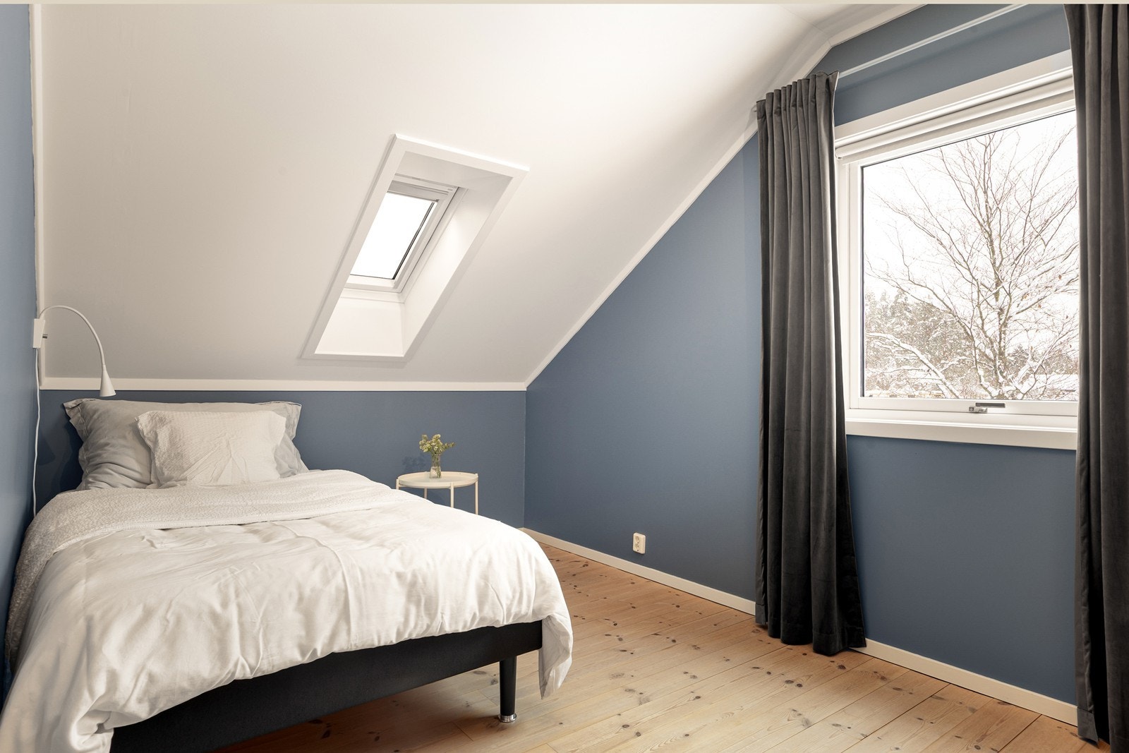 Et av soverommene i andre etasje, med sjarmerende skråtak med takvindu. Galleribilde