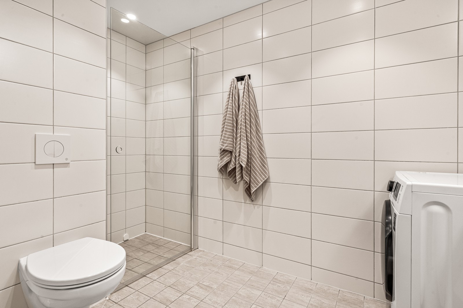 Innfellbare glassdører i dusjen frigjør gulvplass og gjør rommet mer arealeffektivt. Galleribilde