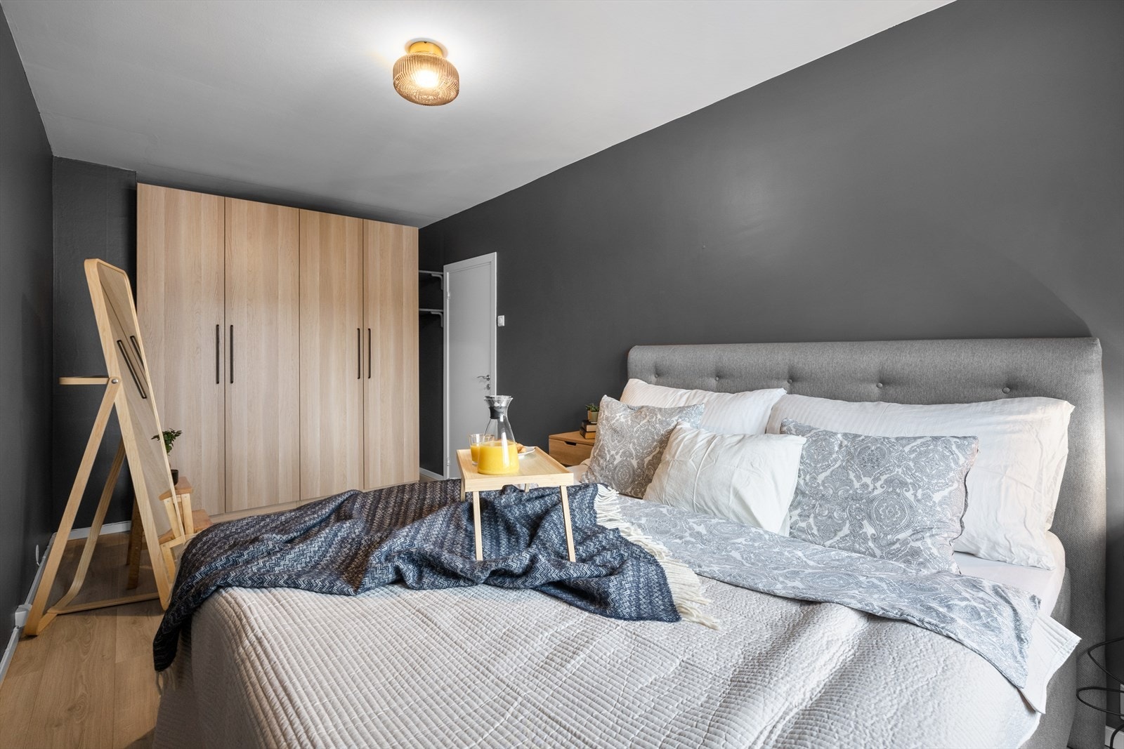 Et lunt og moderne soverom med pene laminatgulv og slette vegger. Galleribilde